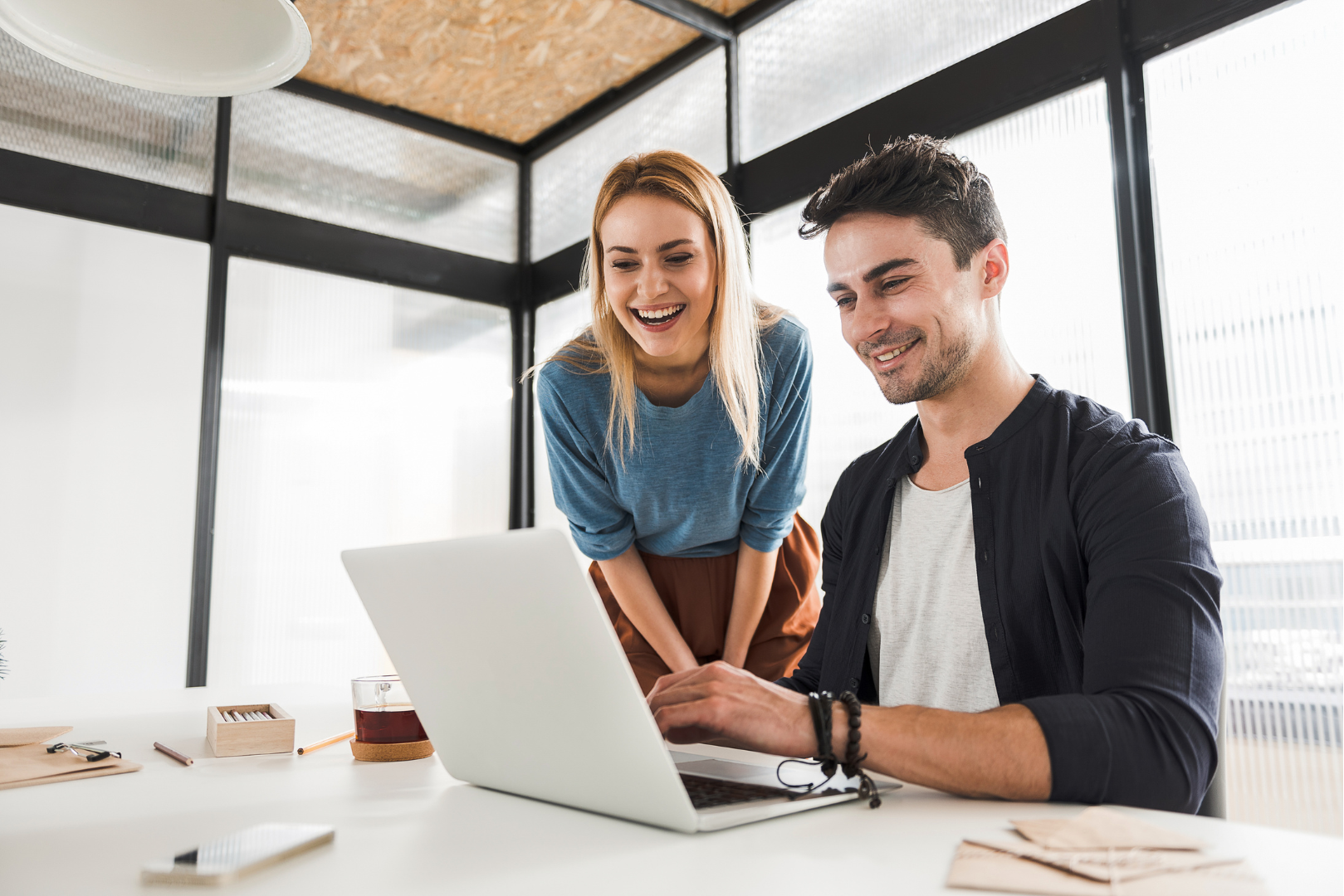 A man and a woman are looking at a laptop computer.