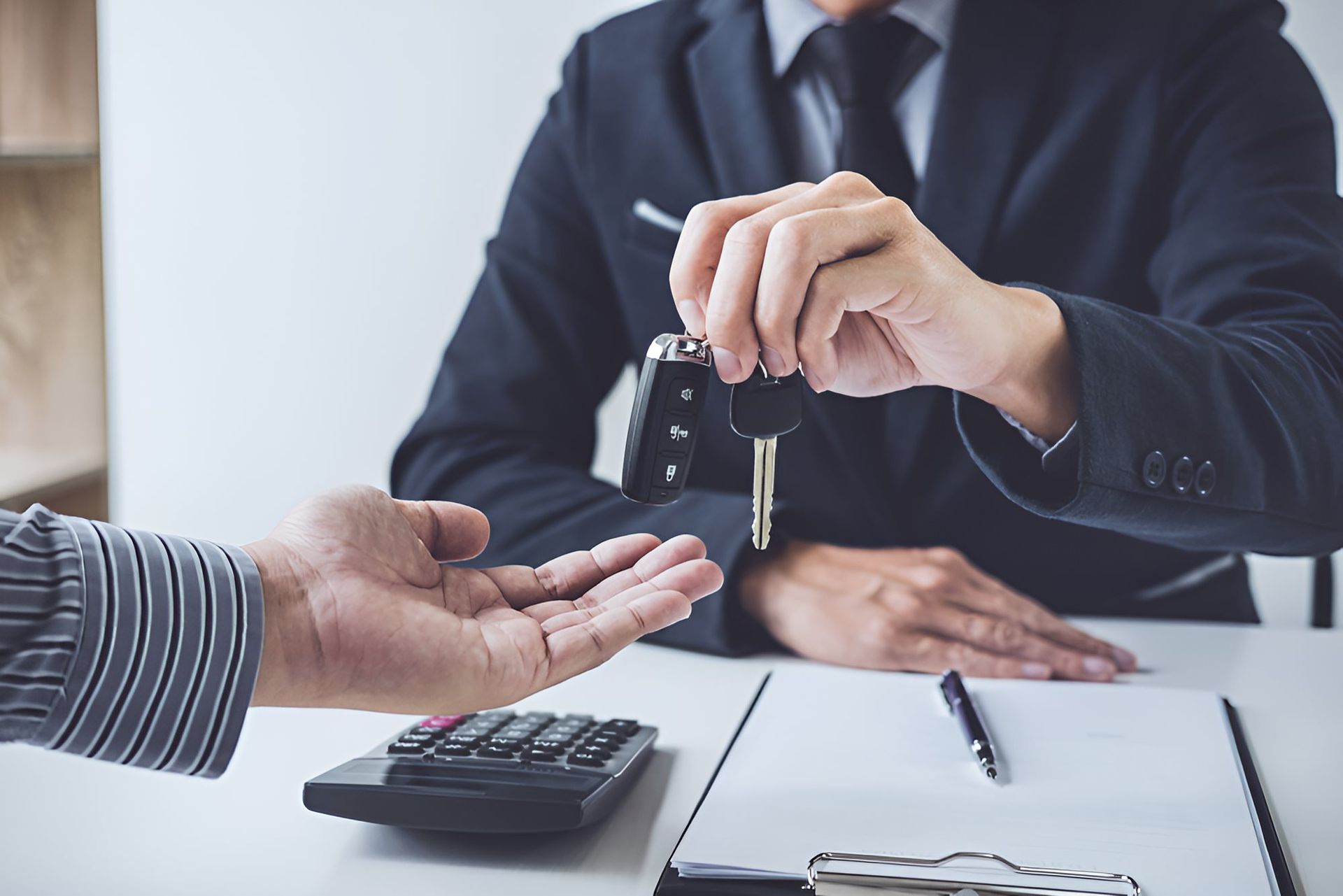 A Man Is Handing Car Keys To Another Man — Optimus 1 Insurance Brokers in Westcourt, QLD