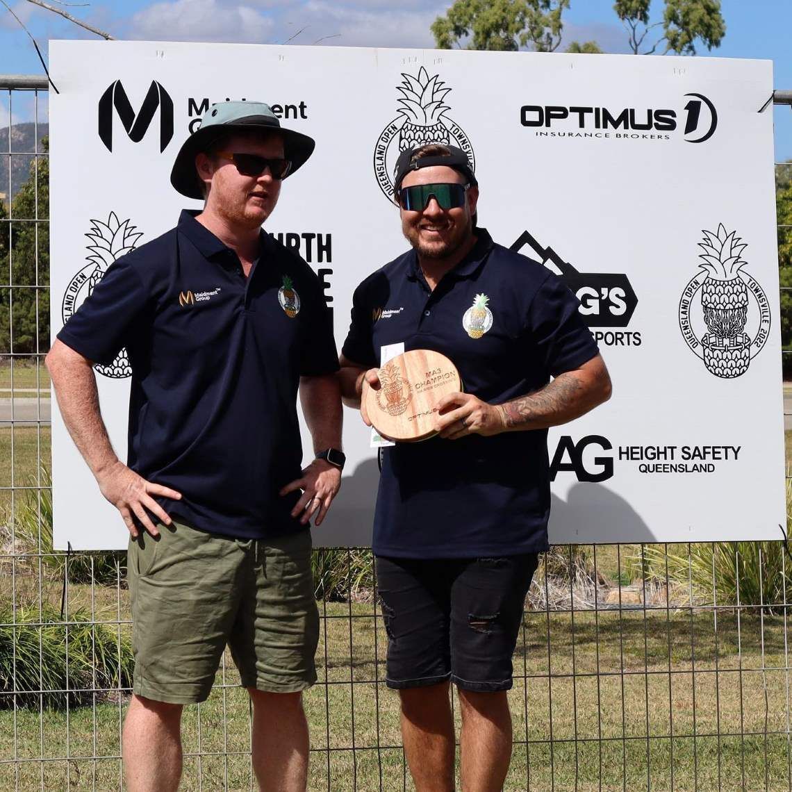 Two Men Standing in Front of a Sign That Says Optimus — Optimus 1 Insurance Brokers in Westcourt, QLD