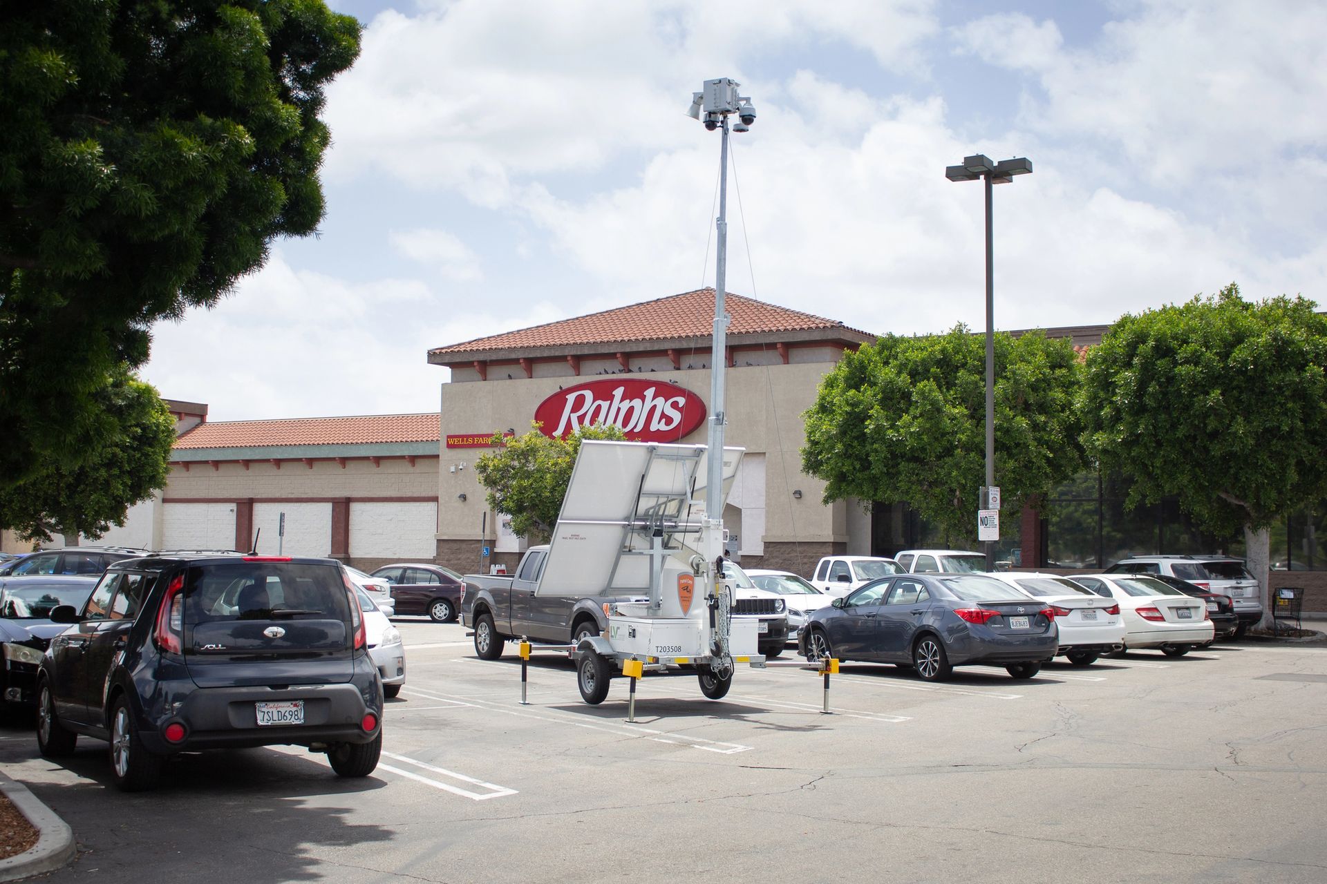 Mobile surveillance unit in a parking lot outside of a Ralphs grocery store on a sunny day.