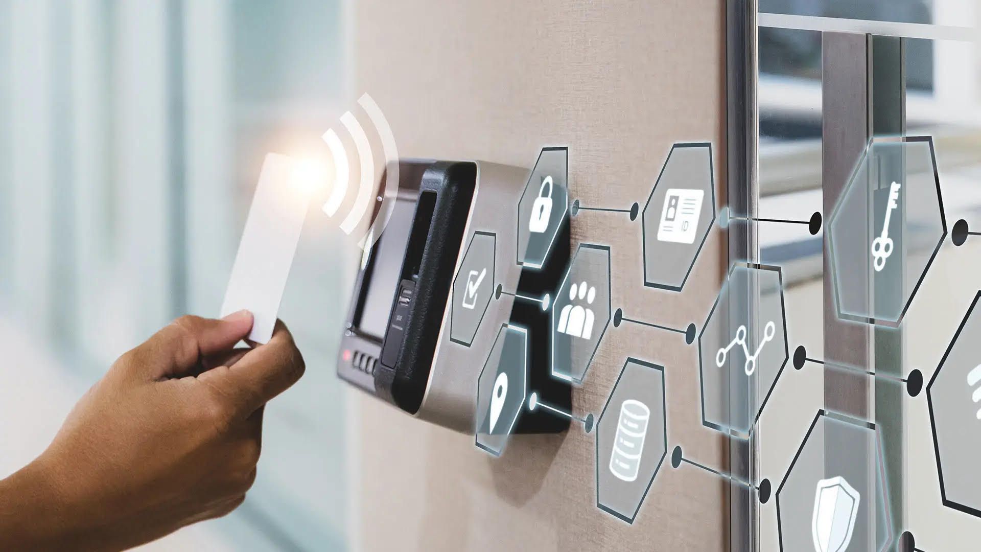 A person holding a card in front of a security system