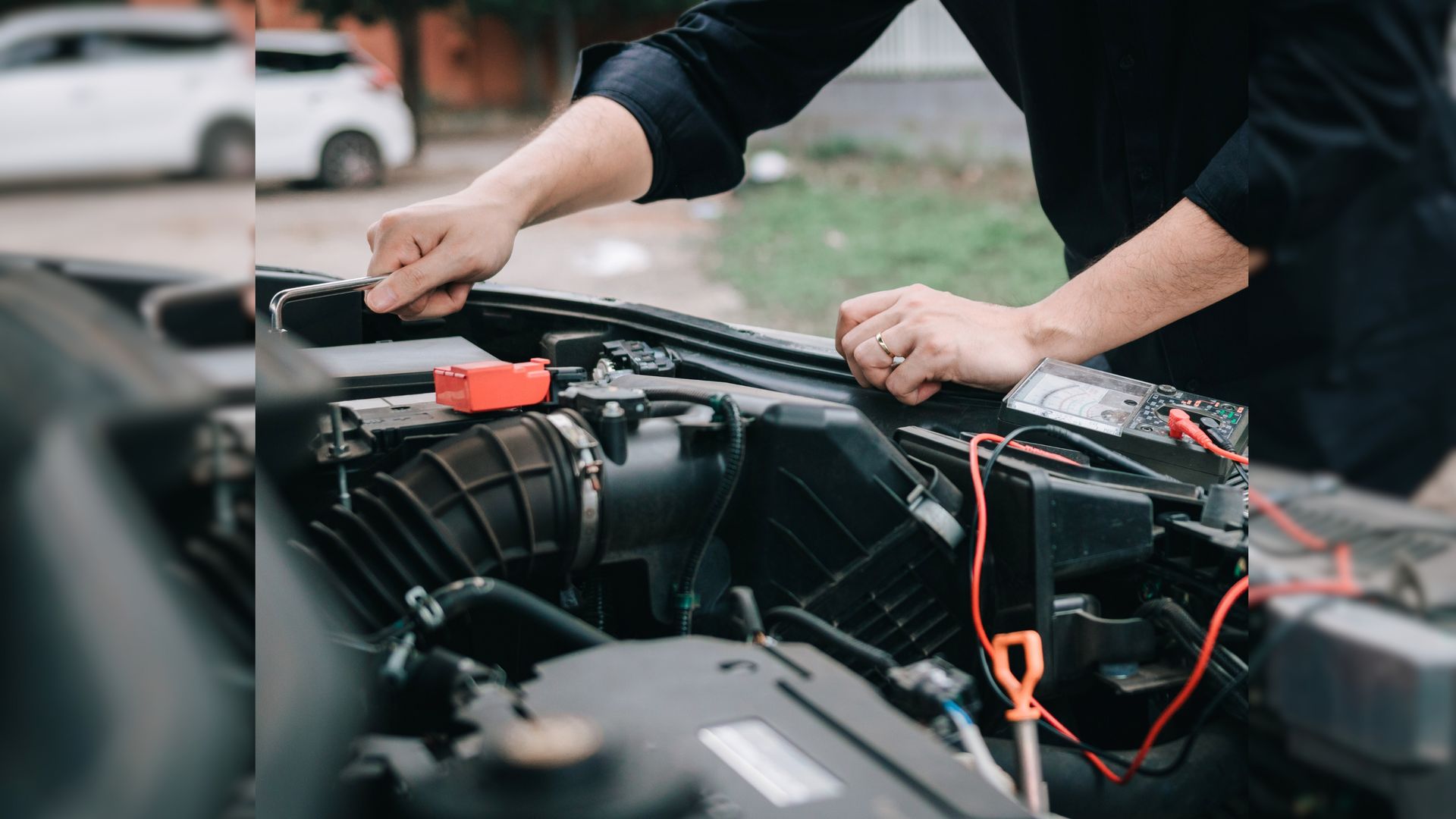 A man is working on the engine of a car.