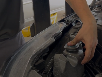 Mechanic checking fluids under the hood of a car.