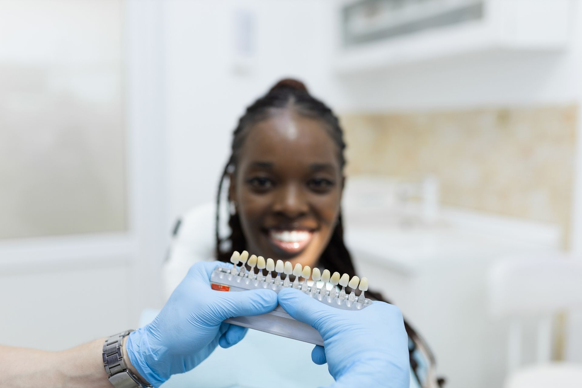 Smiling Black woman in dentist chair showcasing veneers - dental veneer services