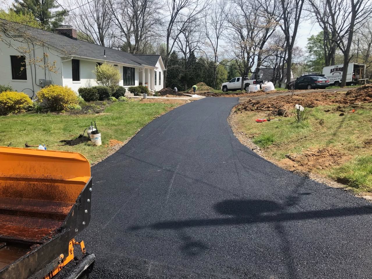 A plow is plowing a driveway in front of a house.