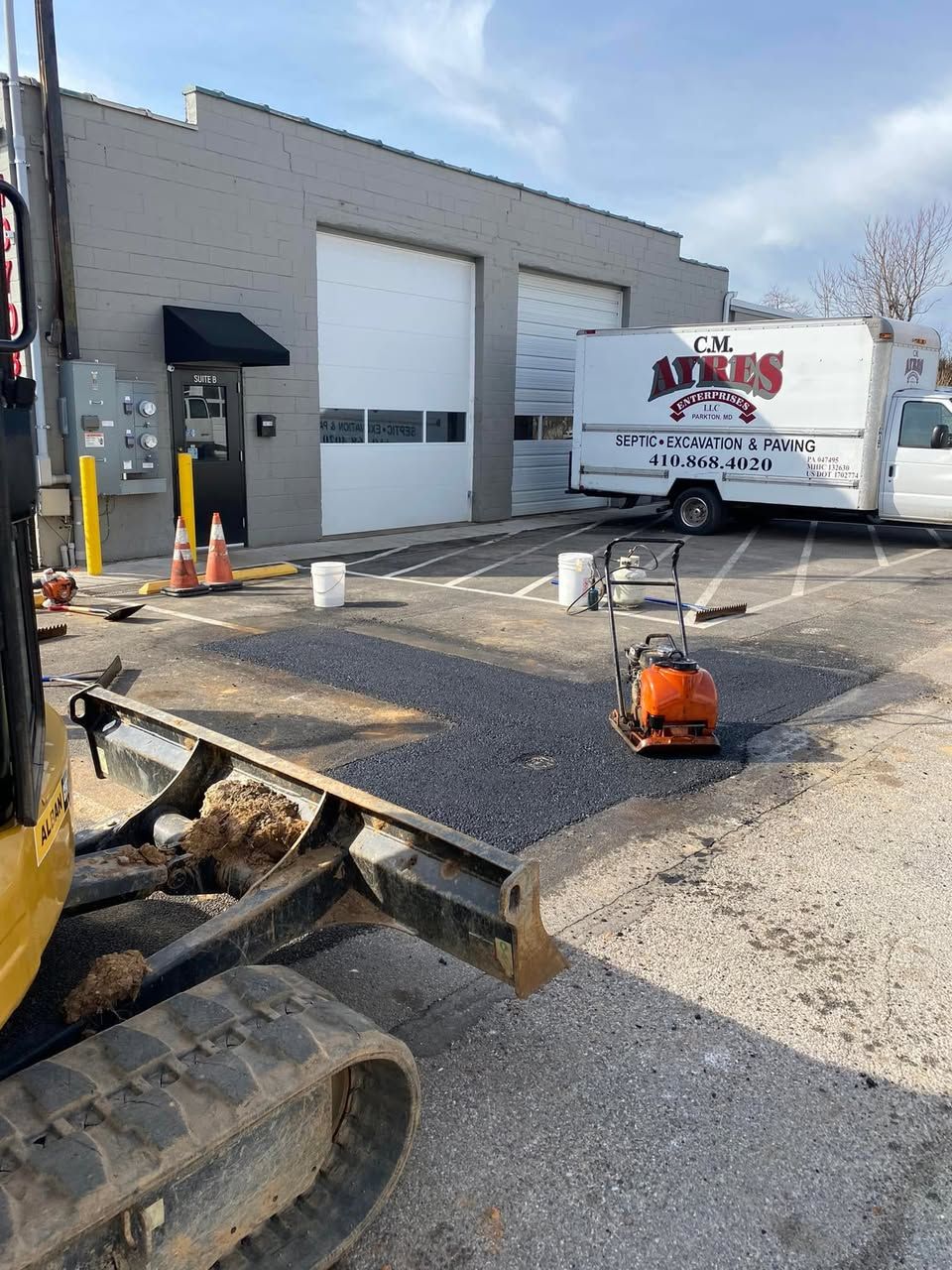 A white truck with the word atlas on it is parked in front of a building.