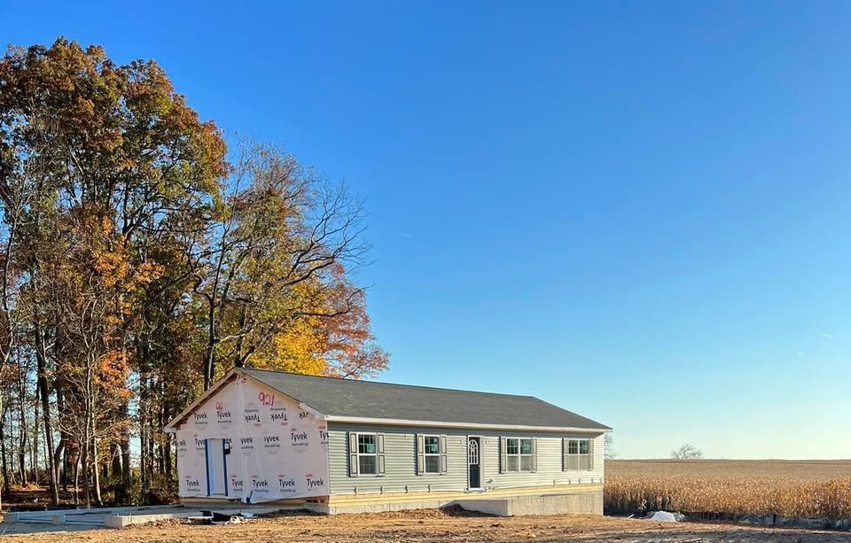 A house is being built in the middle of a field.