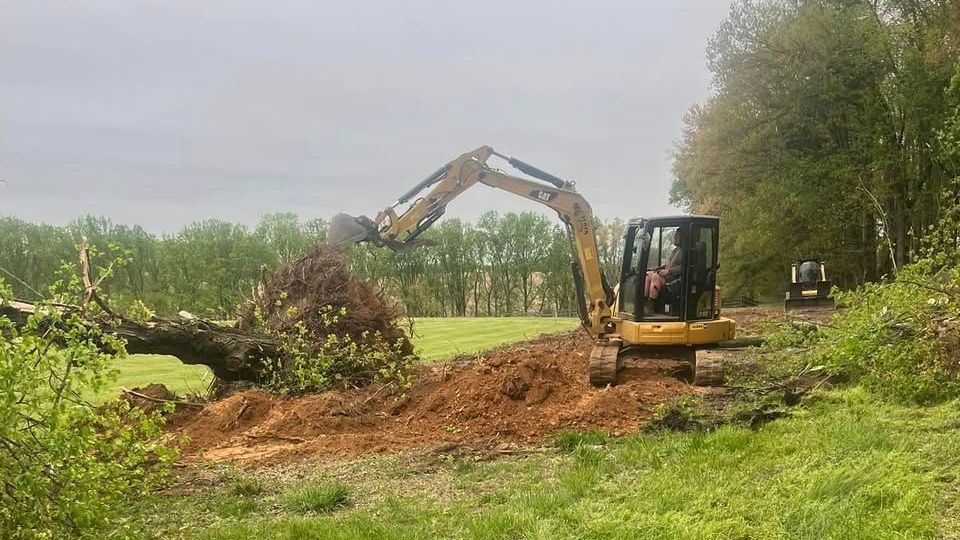 A bulldozer is digging a hole in a field.