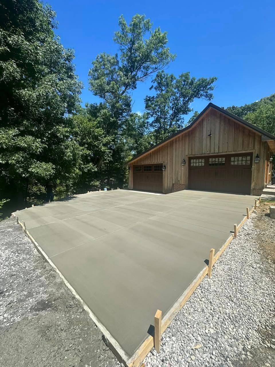 A garage with a concrete driveway in front of it