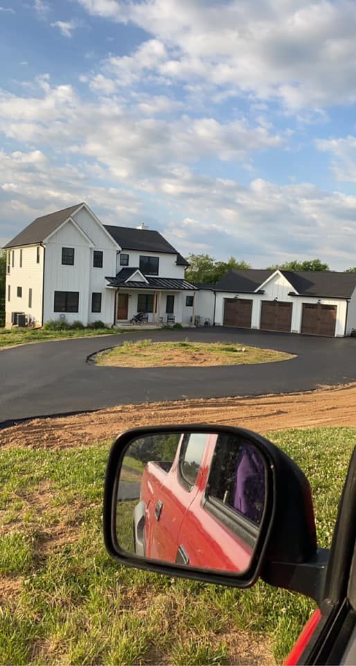 A red truck is parked in front of a large white house.