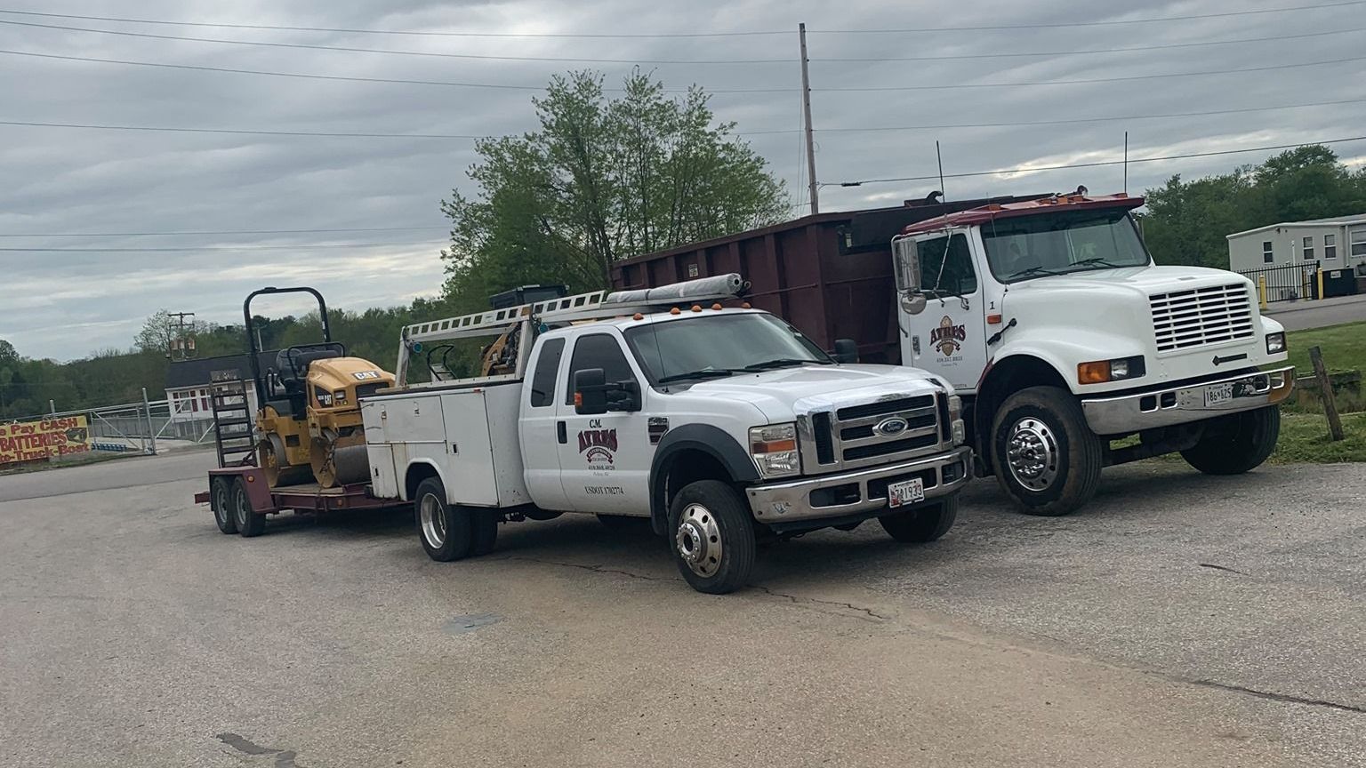 Two trucks are parked next to each other on the side of the road.