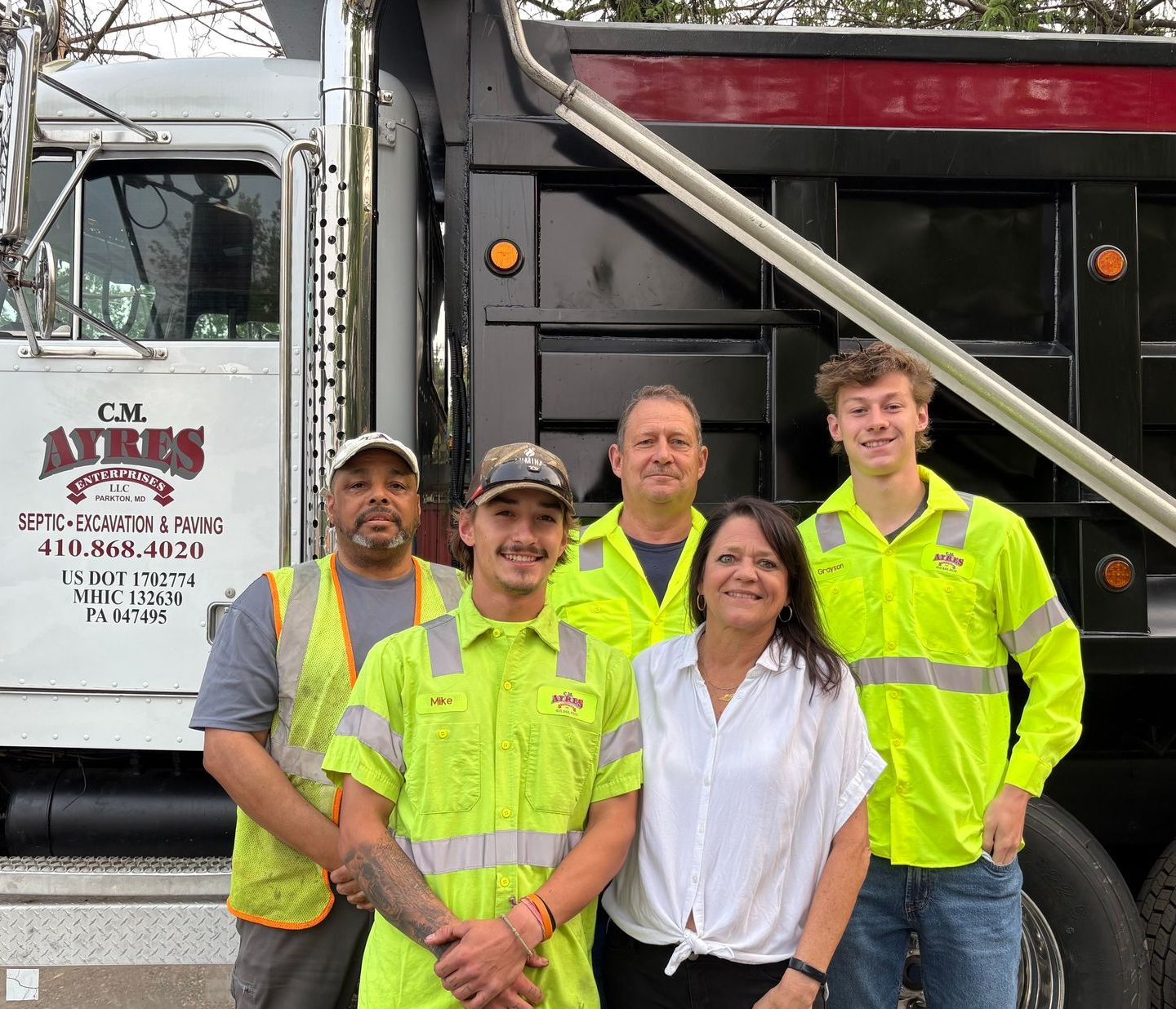 CM Ayres employees smiling and standing in front of a company truck
