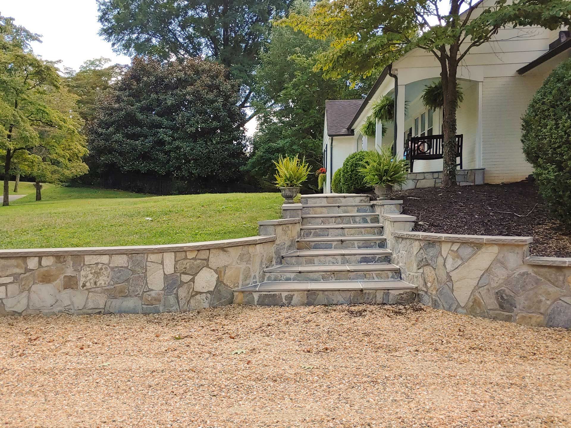A stone wall with stairs leading up to a house