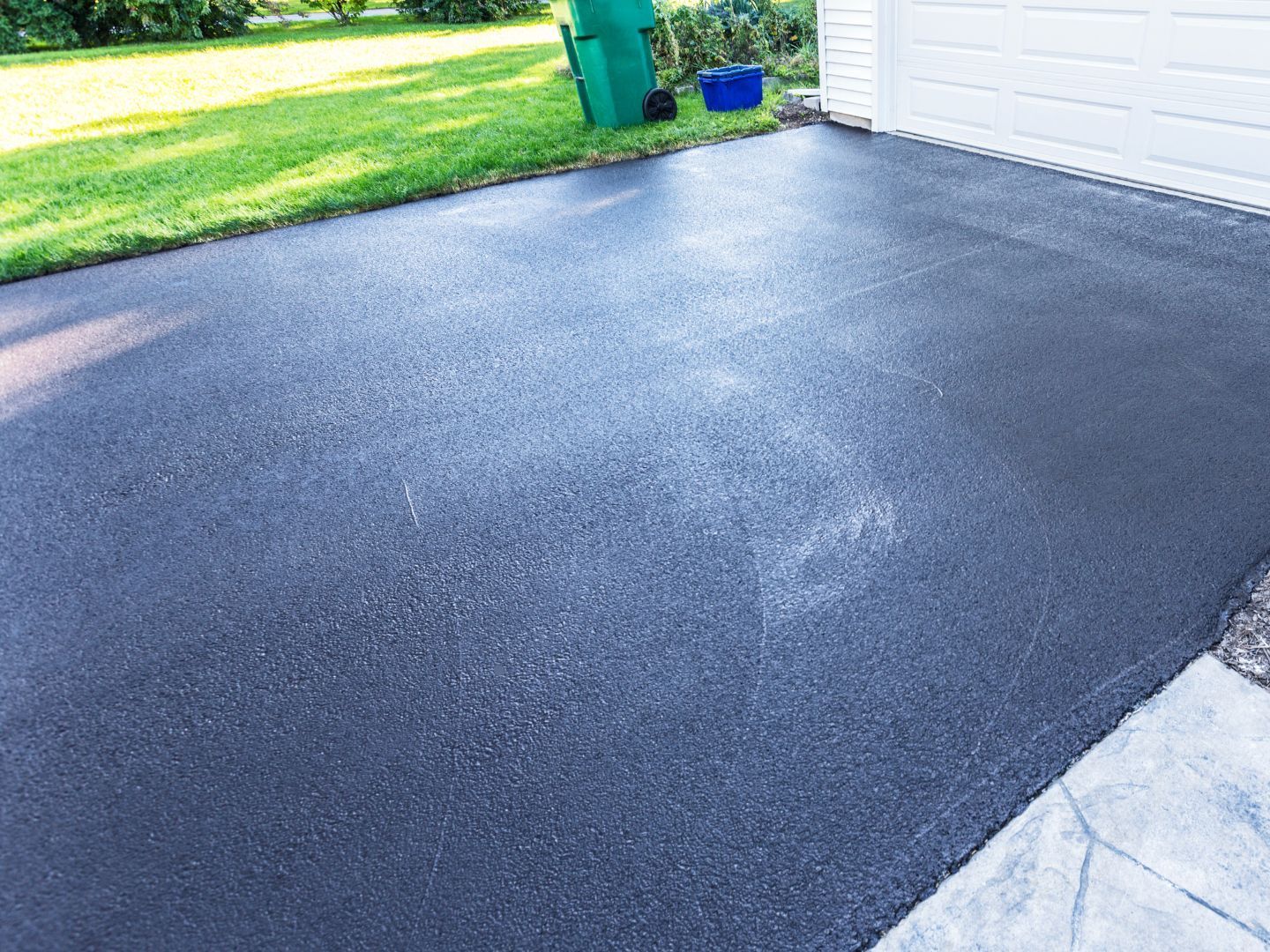 Fresh sealcoating on a residential driveway completed by CM Ayres