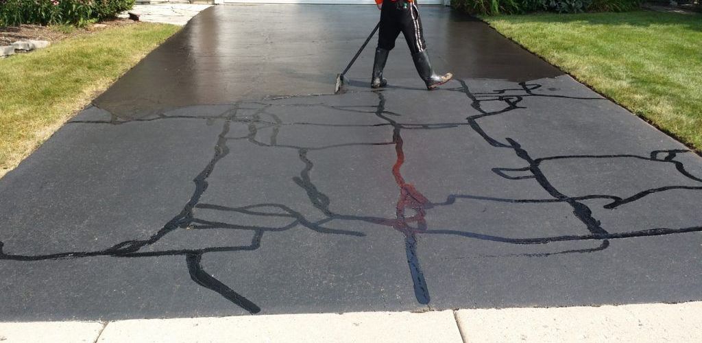 Asphalt crack filling and sealcoating in progress on a Maryland driveway | CM Ayres