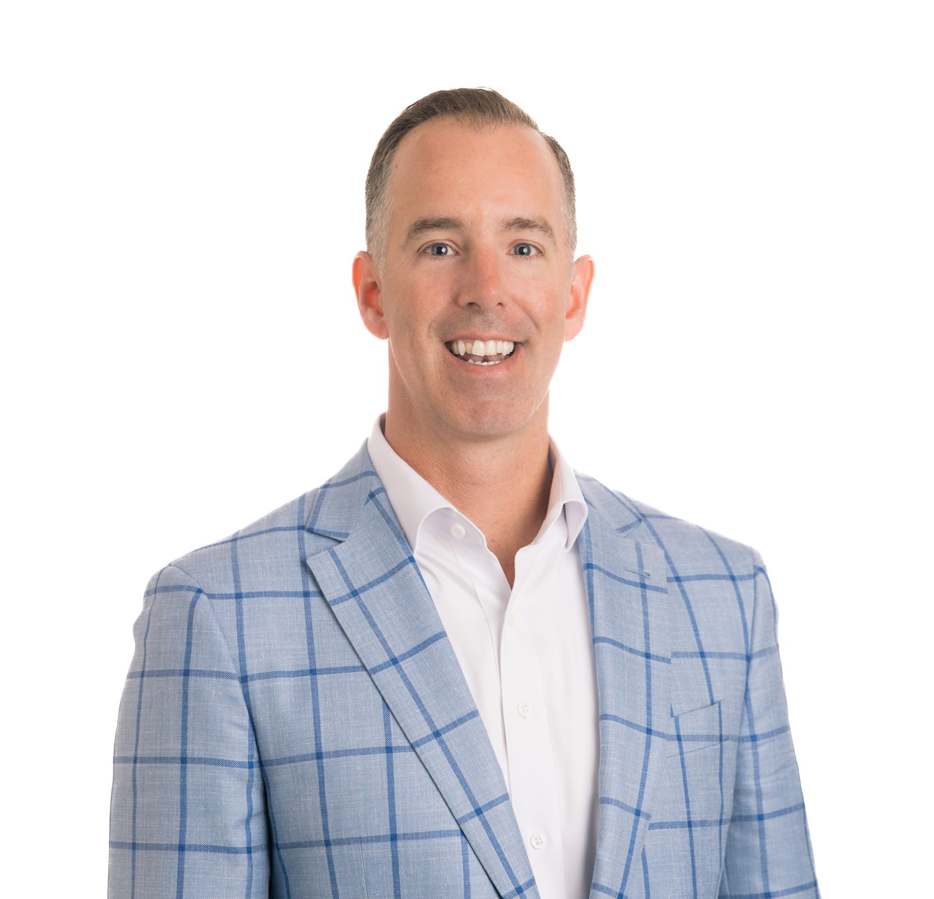Man in blue plaid blazer, smiling, posing against a white background.