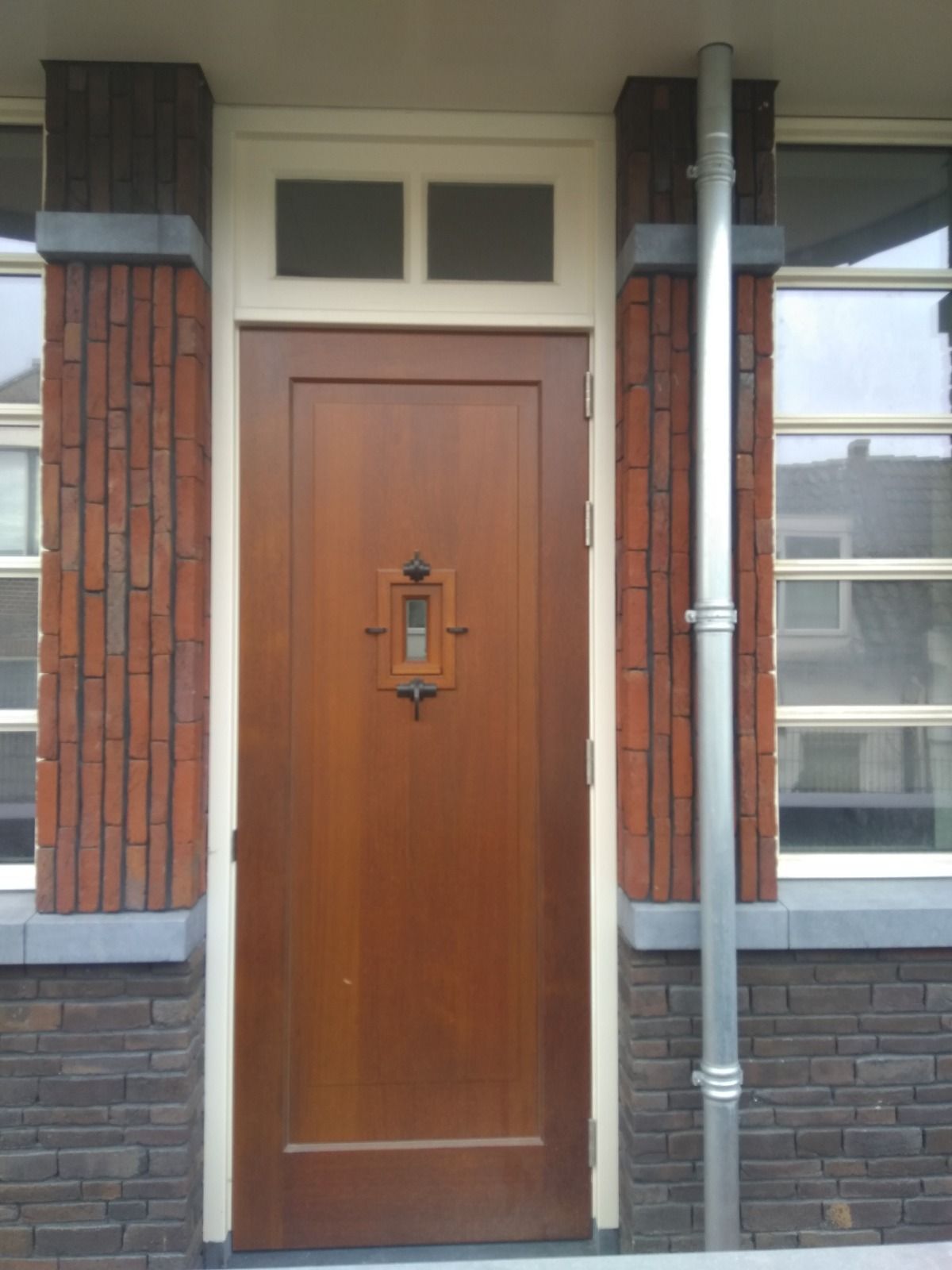 De voordeur van een bakstenen gebouw met een houten deur