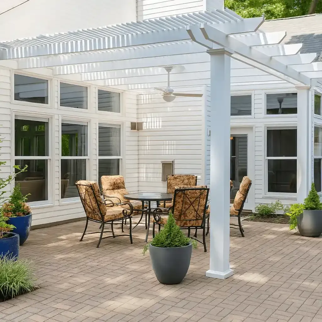 A beautiful white pergola attached to a Richland, Washington, house with a picnic table and chairs underneath it.