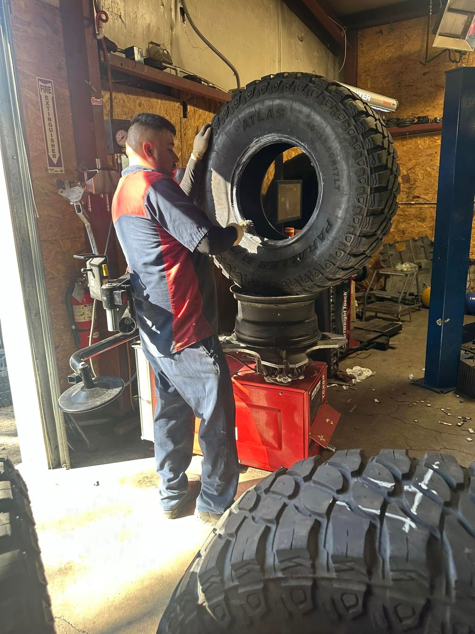 A man is working on a tire in a garage.