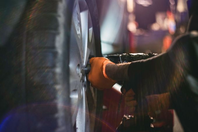 A close up of a person changing a tire on a car.