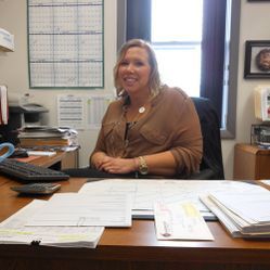 A woman is sitting at a desk in an office.