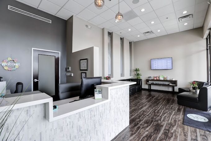 A dental office with a reception desk and a television on the wall.