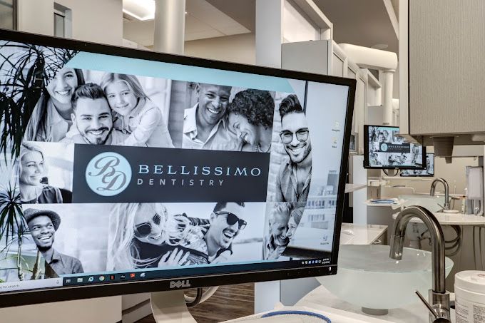 A dell computer monitor is sitting on a desk in a dental office.