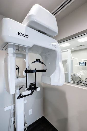 A large white machine is sitting in a room next to a window.