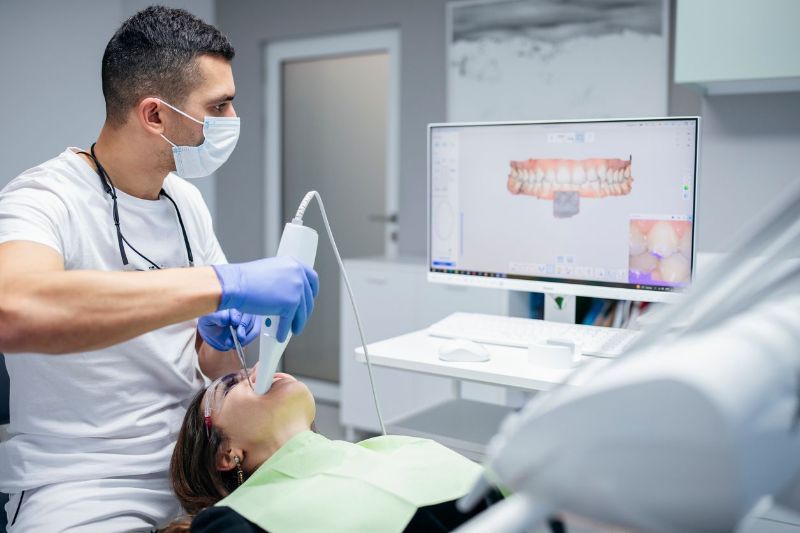 A dentist is examining a patient 's teeth in a dental office.