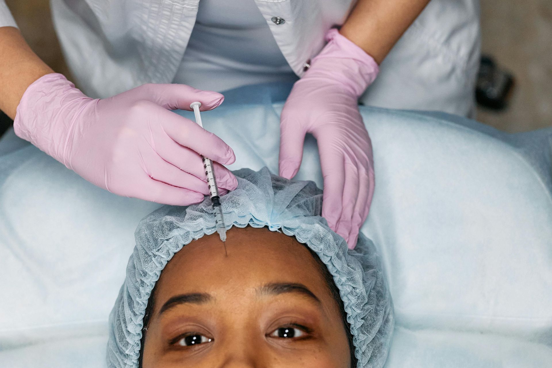 A woman is examining a man 's teeth in a dental office.