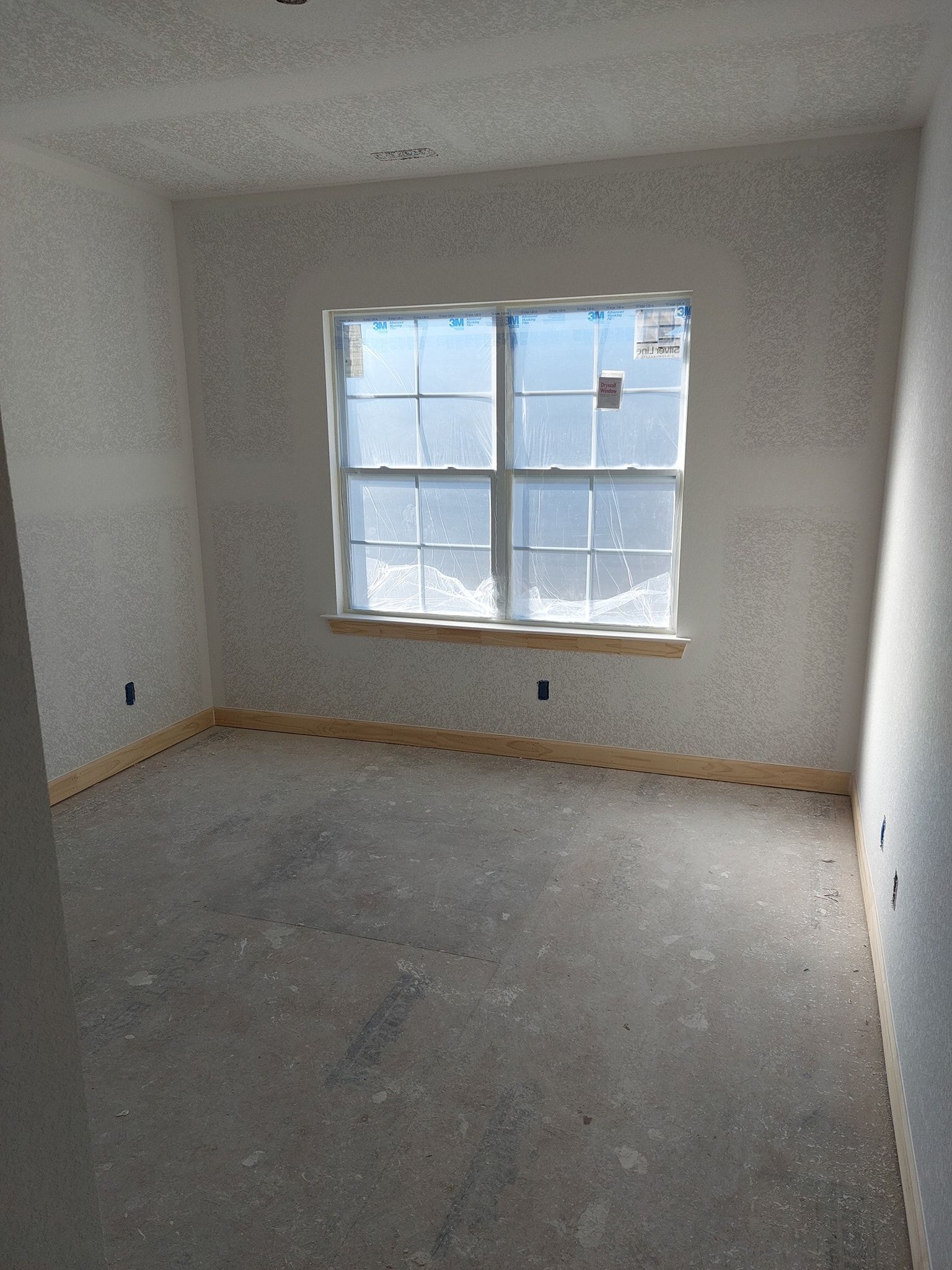 Empty carpeted room with white walls, a window, and natural light coming in.