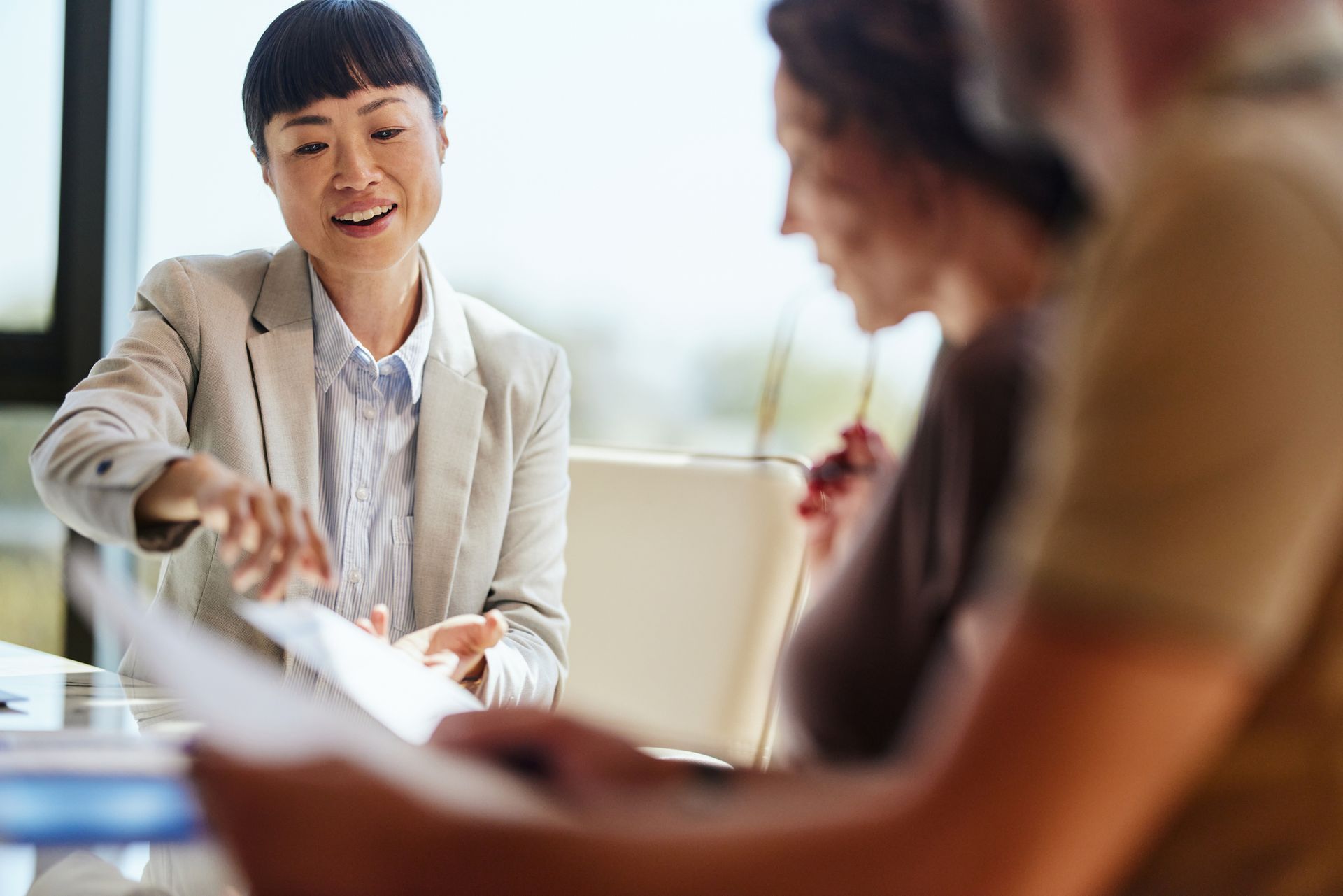 A friendly car insurance representative assisting a couple at a meeting table.