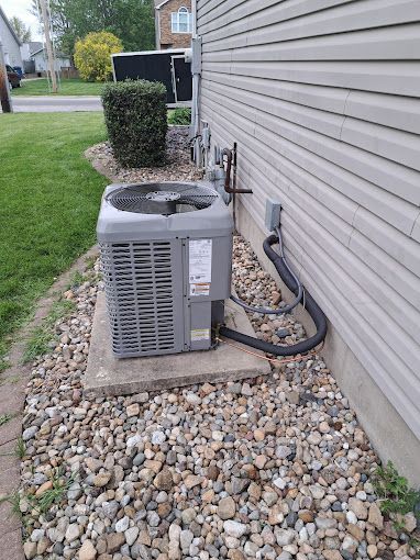 An air conditioner is sitting on the side of a house.