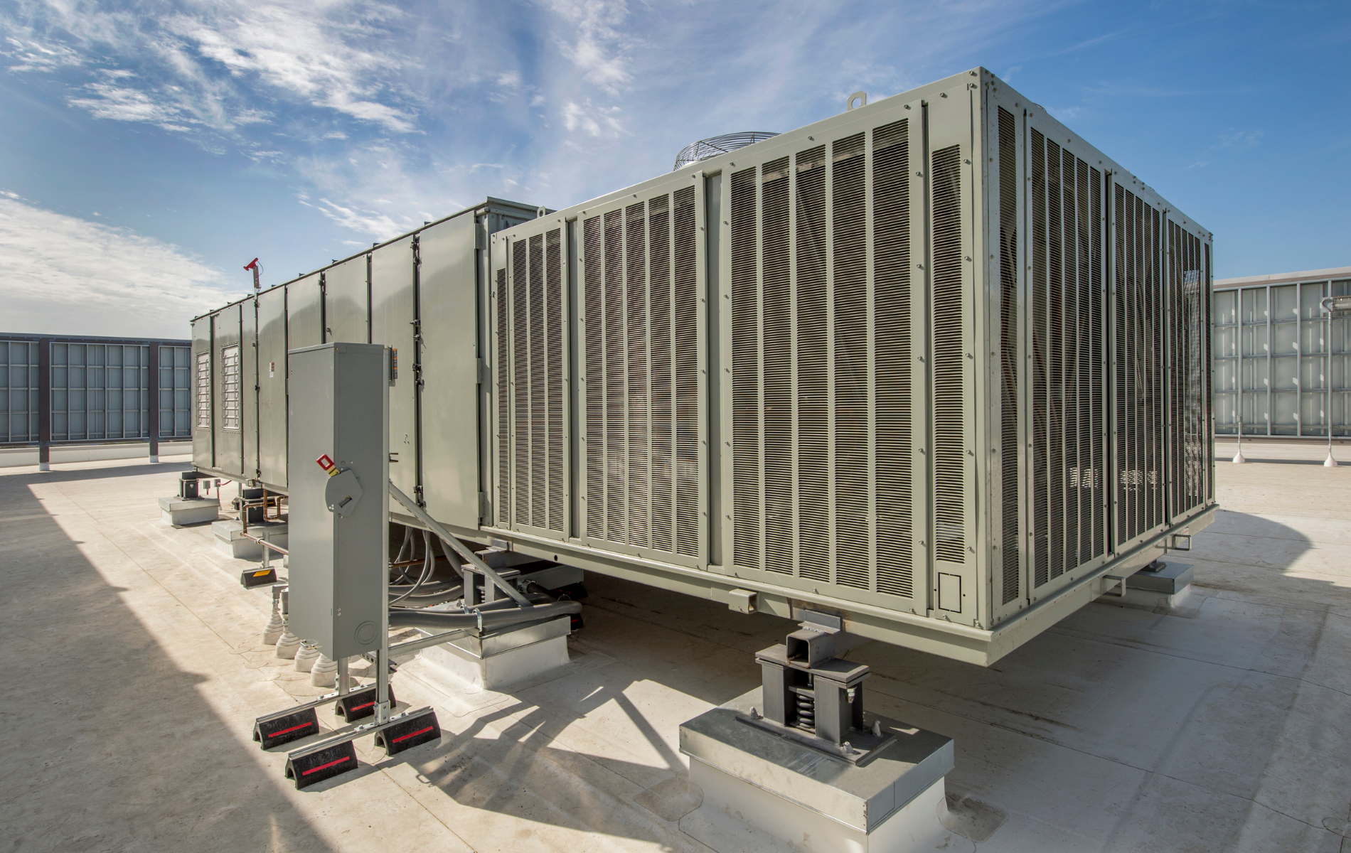 A large air conditioner is sitting on top of a roof.