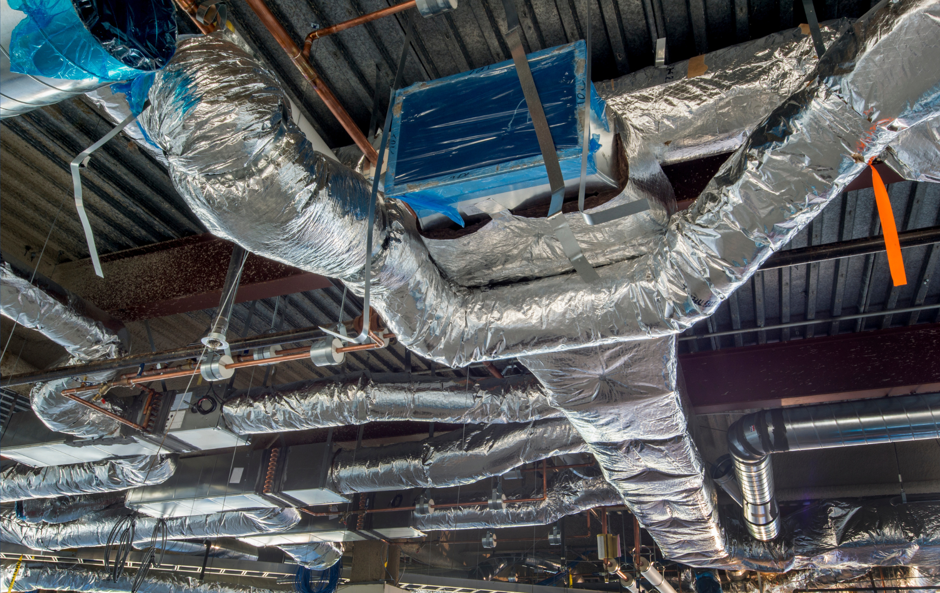 A bunch of pipes hanging from the ceiling of a building.