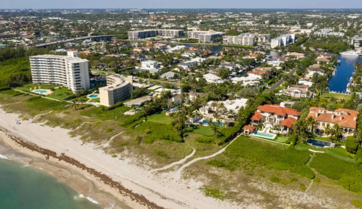 An aerial view of a beach with a city in the background.