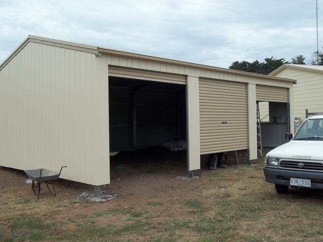 A white van is parked in front of a garage