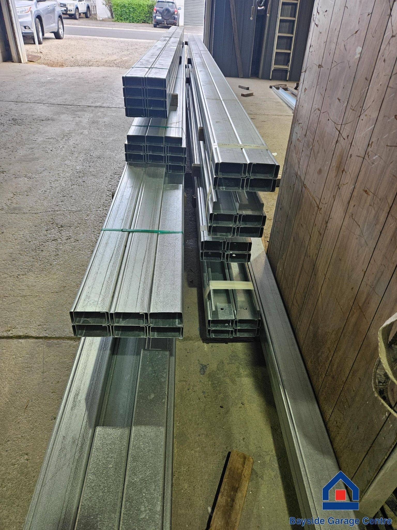 A bunch of metal tubes are stacked on top of each other in a garage.