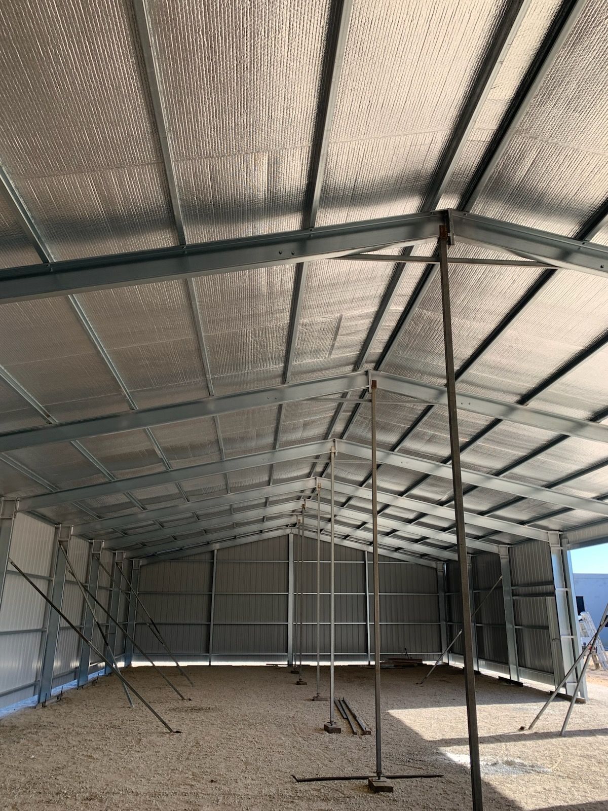 A large metal structure with a roof that is covered in insulation.