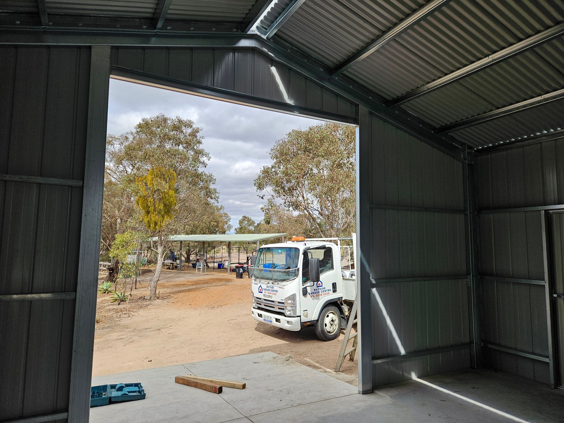 A white truck is parked in a garage with the door open.