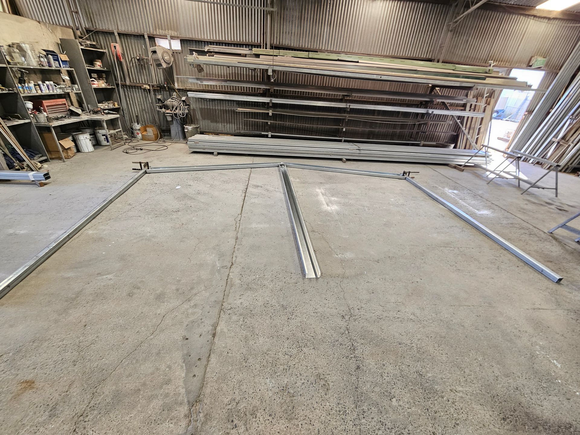 A warehouse with a lot of metal pieces on the floor