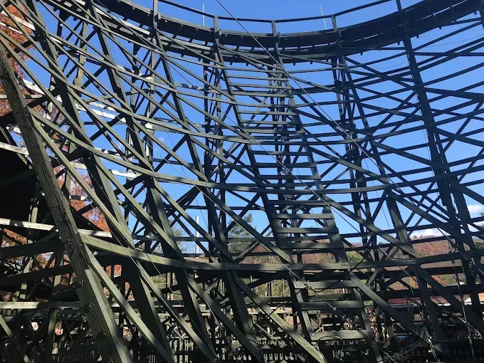 A roller coaster with a blue sky in the background.