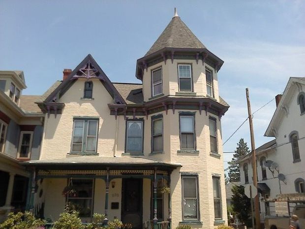 A large white house with a purple roof A large white house with a purple roof