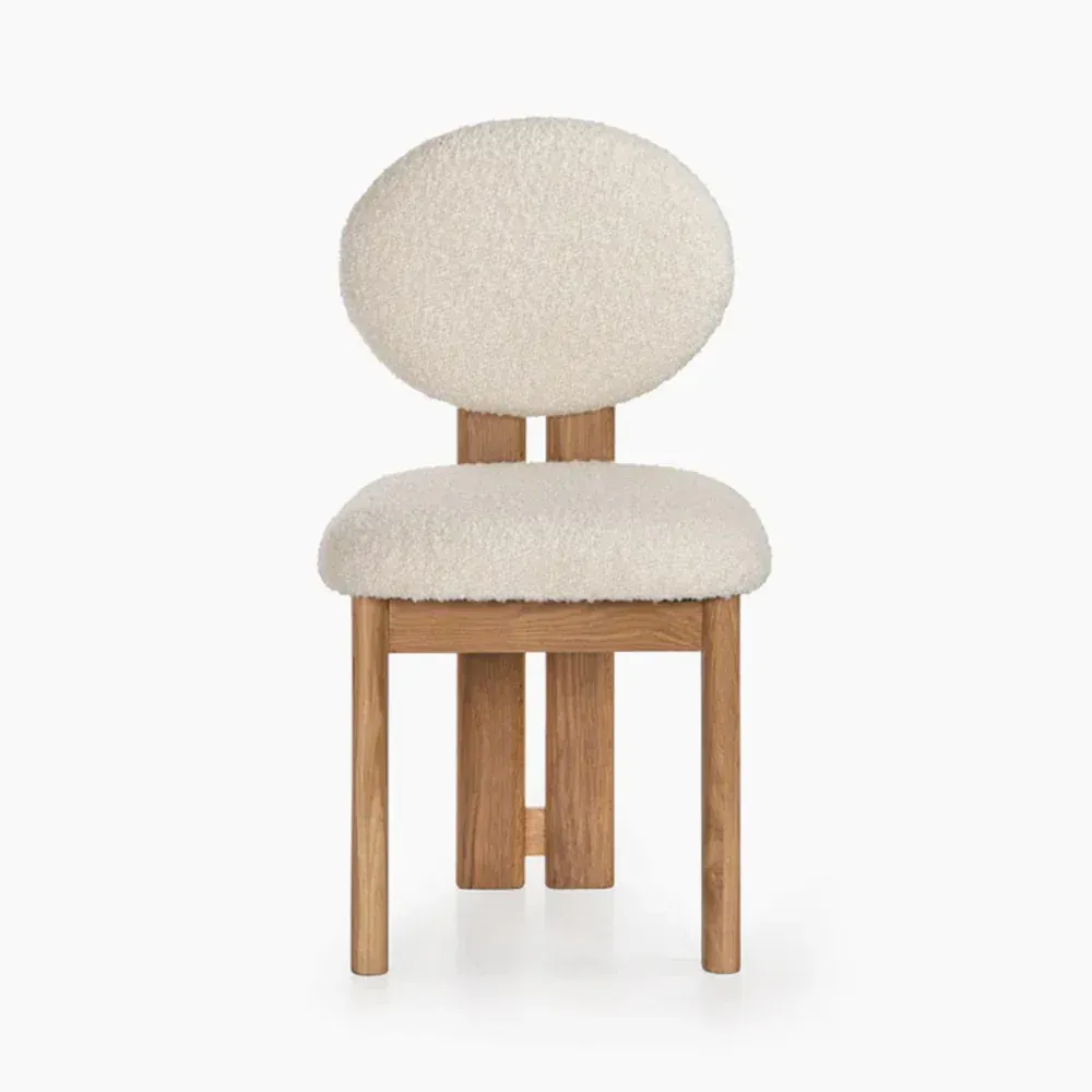 Cream boucle chair with a wooden frame.