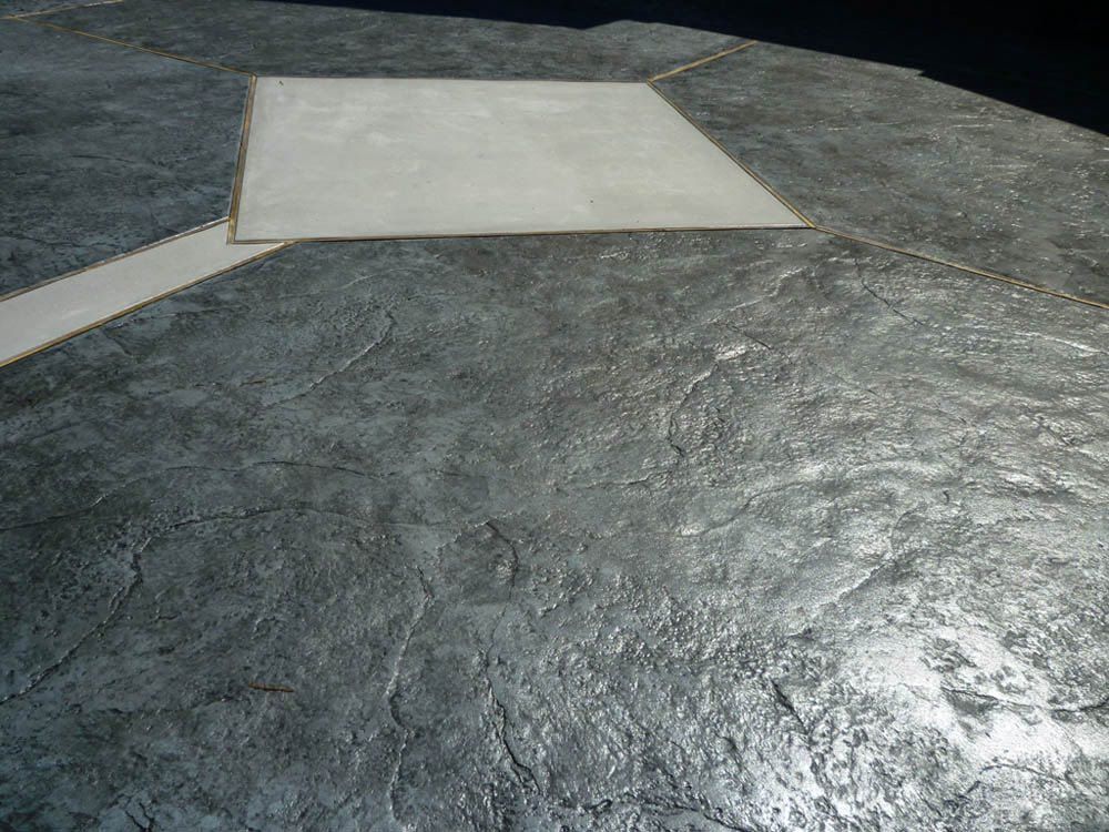 Textured gray concrete patio with a lighter square inset.