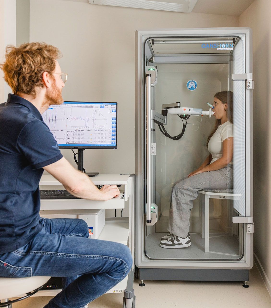 Lungenfunktionsprüfung in einer Kabine, Arzt sitzt am Computer