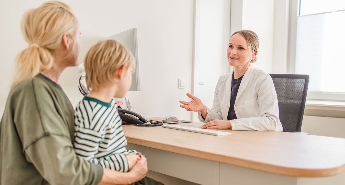 Praxis Kramer + Arndt, Mutter mit Kind spricht mit Ärztin