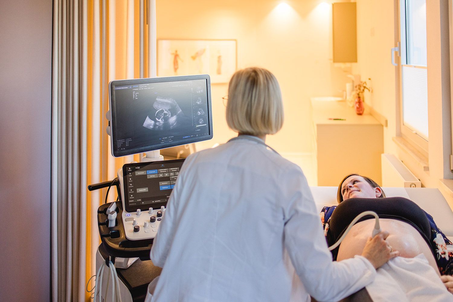 Ärztin untersucht eine schwangere Patientin mit einem Ultraschallgerät