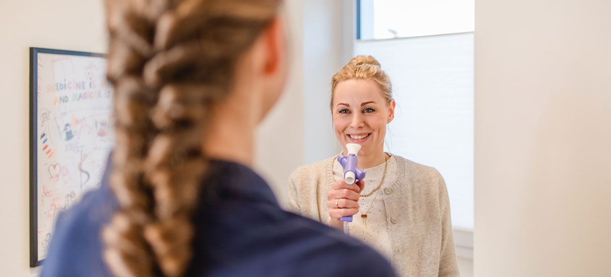 Spirometrie - Patientin hält ein Mundstück in der Hand