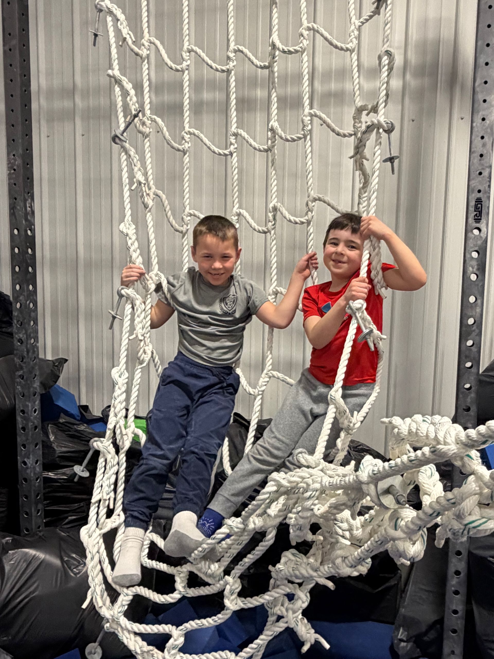 Child in red shirt using an elliptical machine in a gym